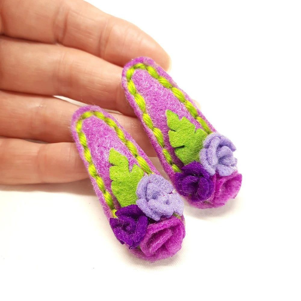 Cute hair clips covered in purple felt with matching roses and stitching. Gentle on delicate hair.