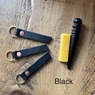 English veg tanned shoulder leather key fobs in black with brass split rings and copper saddlers rivets.