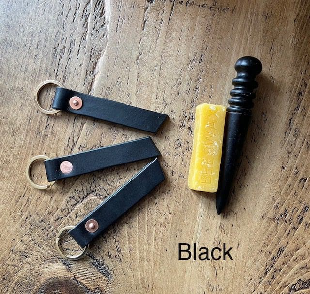 English veg tanned shoulder leather key fobs in black with brass split rings and copper saddlers rivets.