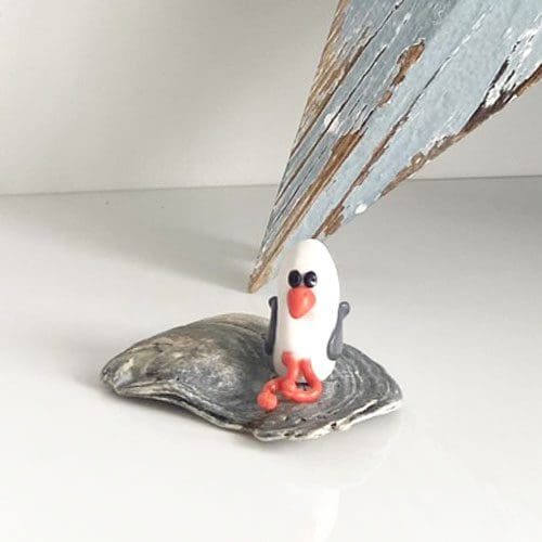 Miniature polymer clay seagull set on a sea shell