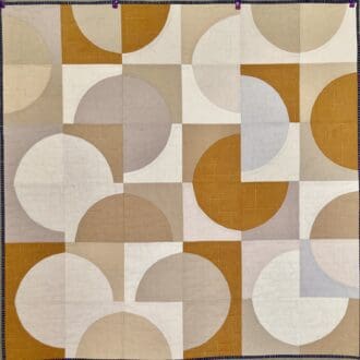 Warm neutral handmade baby quilt with circles