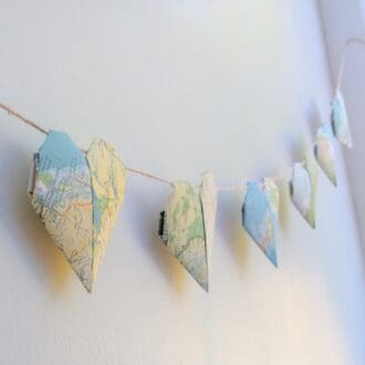 Garland of origami hearts on wall made from maps