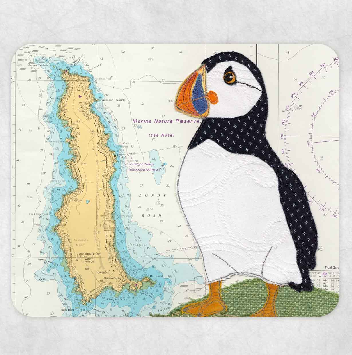 Placemat printed with a textile art design of a puffin on an old sea chart