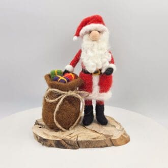 Needle felted Santa Claus with sack on wooden base
