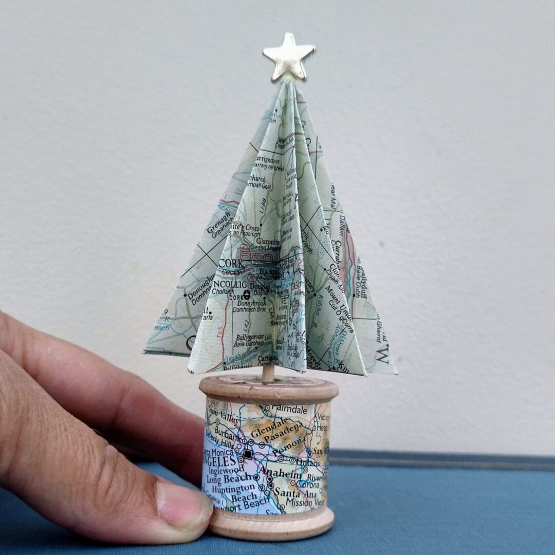 Custom map Christmas tree with hand holding it for scale