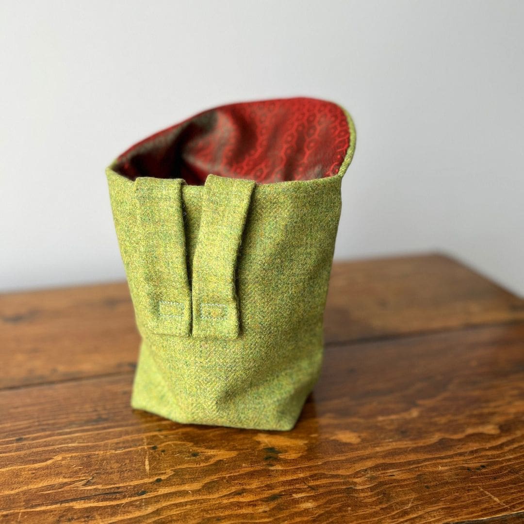 small green bag open to show the red lining