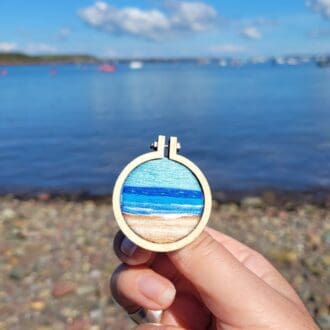 Hand embroidered seascape brooch set in a mini embroidery hoop frame 4cm.