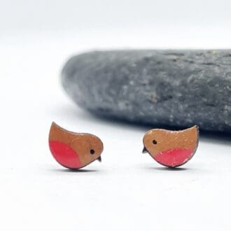 Sweet colourful robin earrings on white background in front of a grey slate stone.