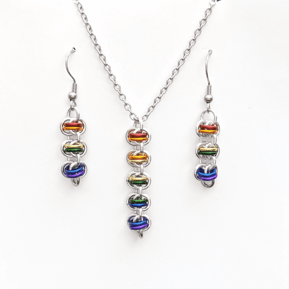 a matching necklace and earring set. The pendant and earrings have been made using rainbow coloured rings woven into the chainmaille barrel weave pattern.