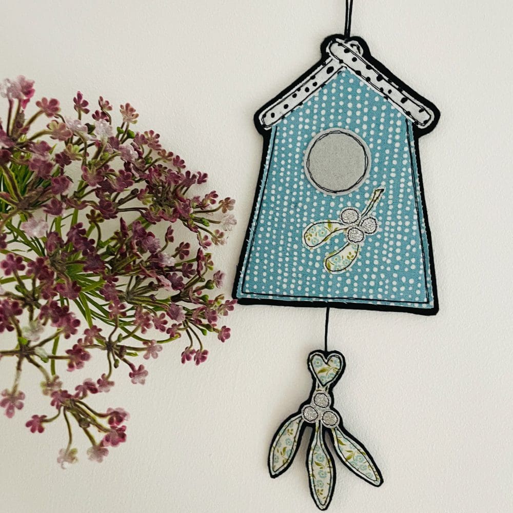 Textile christmas bird house hanging decoration with glitter mistletoe and snowy roof