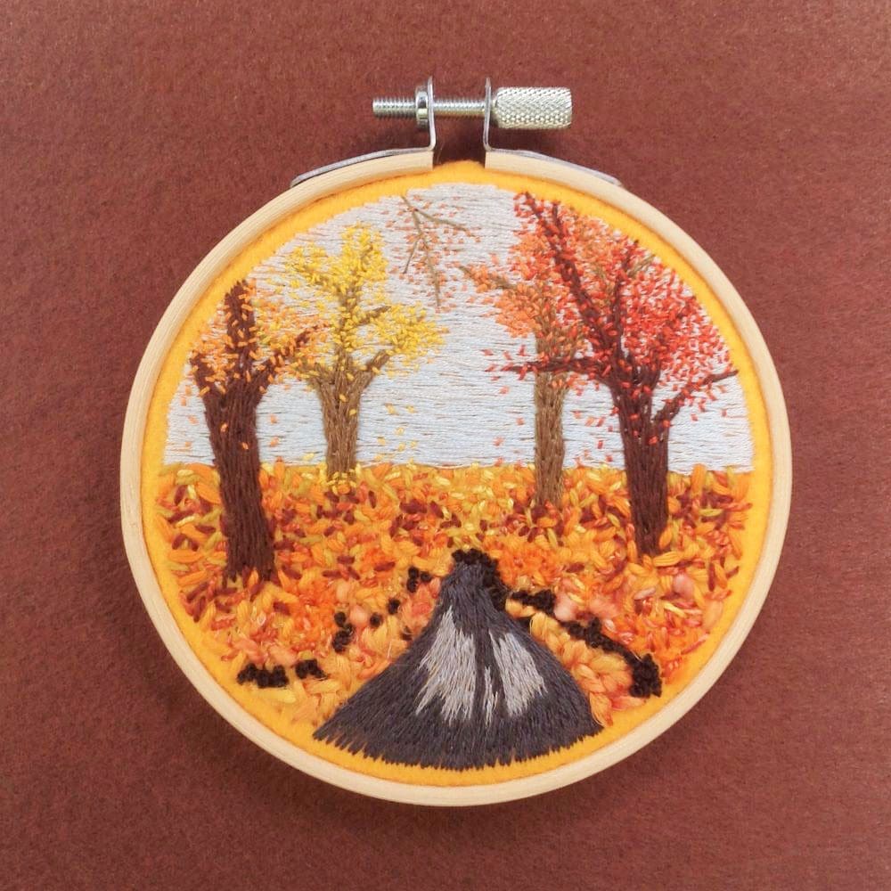embroidered picture reflects an autumn wooded landscape