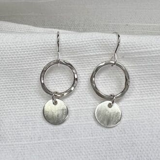 Sterling silver handmade earrings with a hammered hoop and satin finish circle