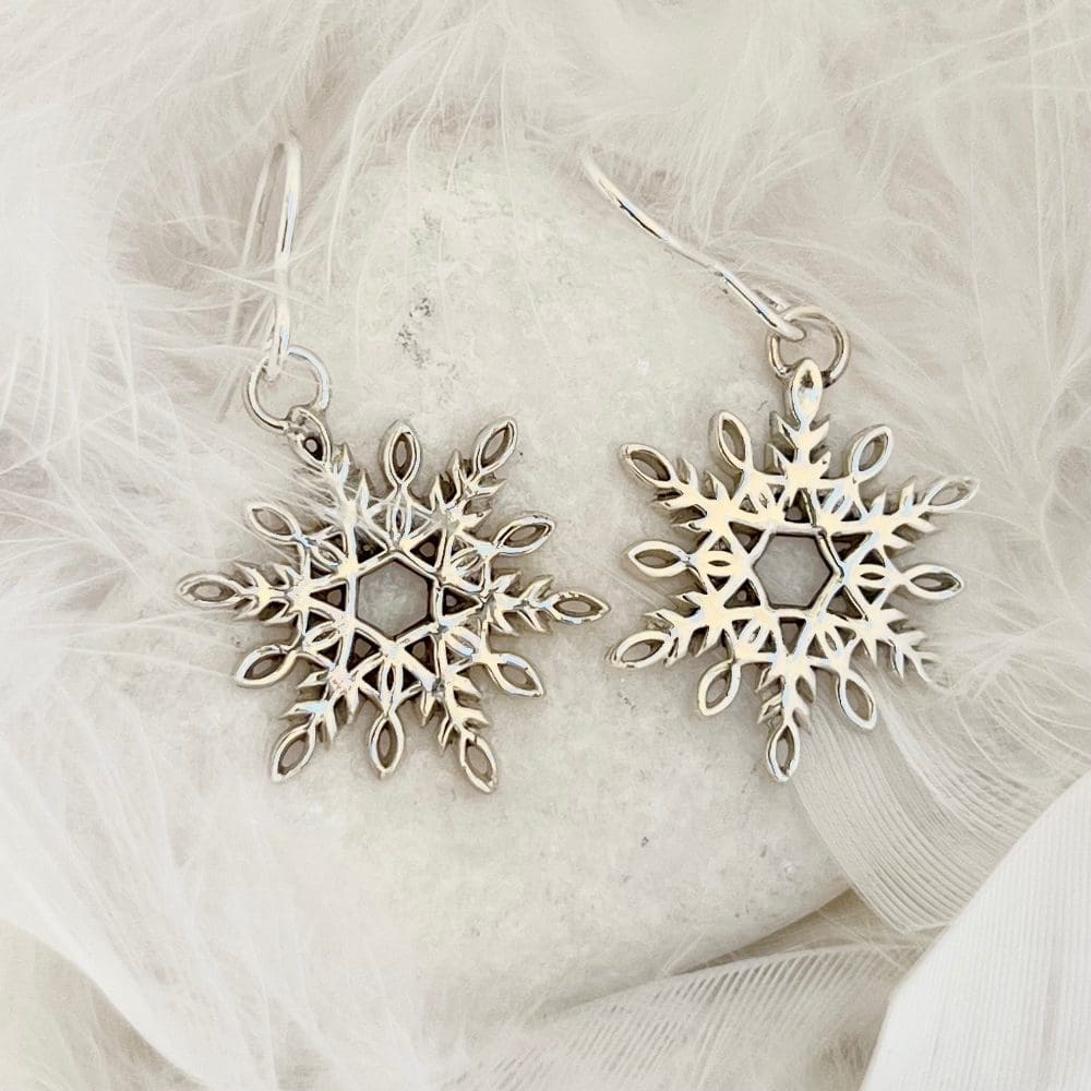 A pair of handmade silver snowflake dangle earrings