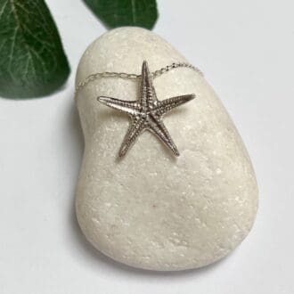 A silver starfish necklace which has been handmade in recycled fine silver