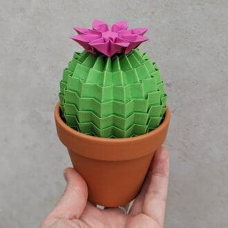 Lime green origami cactus in a terracotta pot with a bright pink paper flower on top