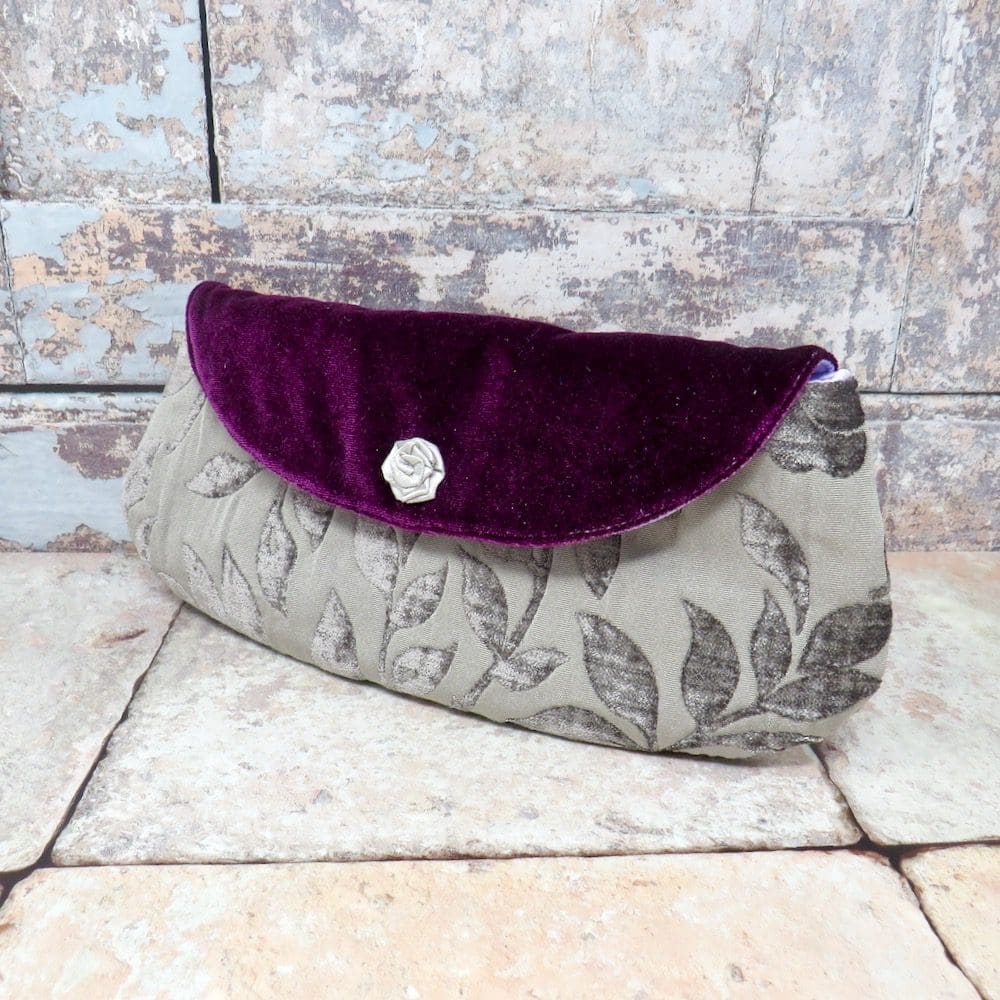 A mid sized clutch in mauve textured velvet and with a purple velvet flap.