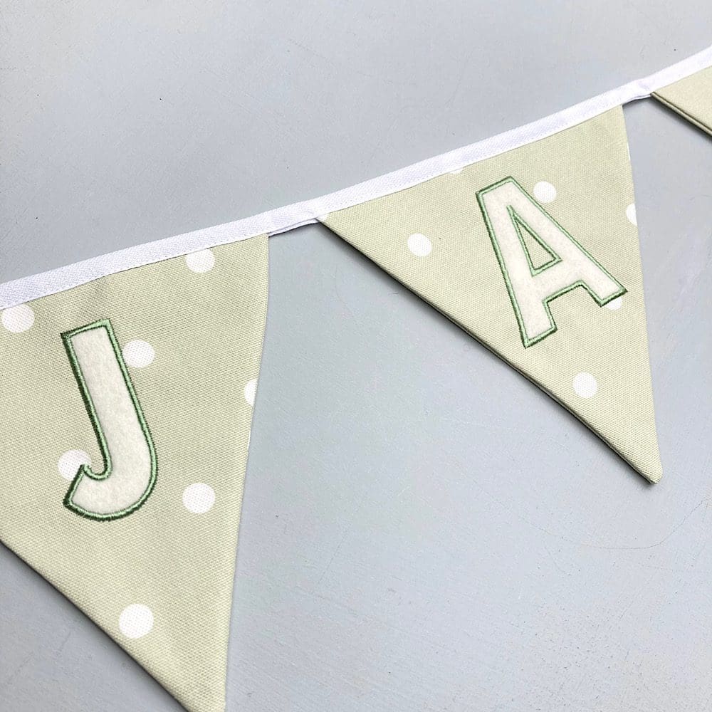Personalised sage green bunting hung on wall