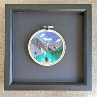 framed embroidered picture of a mountain lake scene