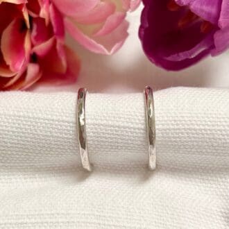 A pair of handmade sterling silver hoop earrings with hammered finish