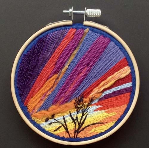 a dramatic hand embroidery of the setting sun