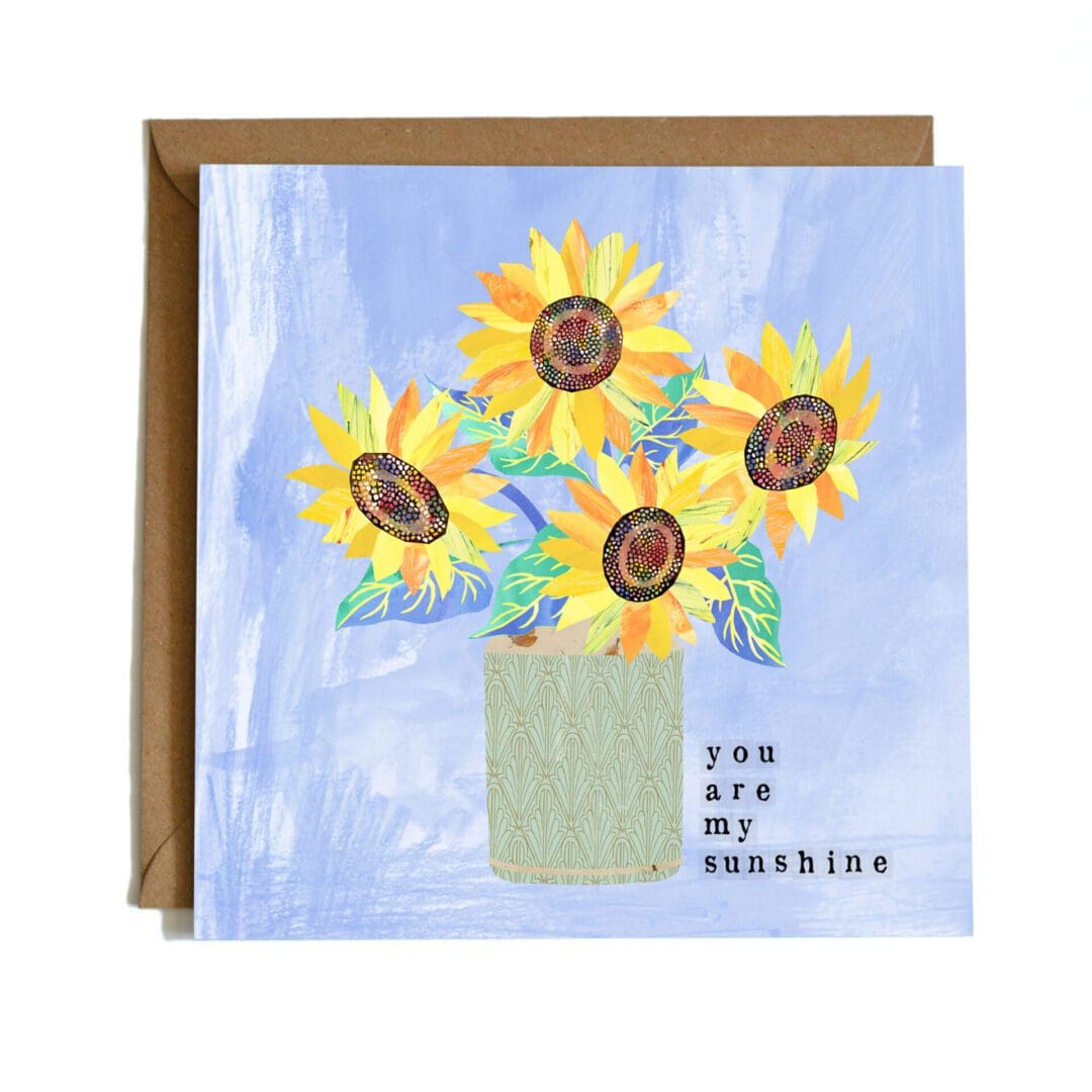 A square card featuring a digital illustration of a vase of sunflowers on a blue background with the words 'you are my sunshine'.