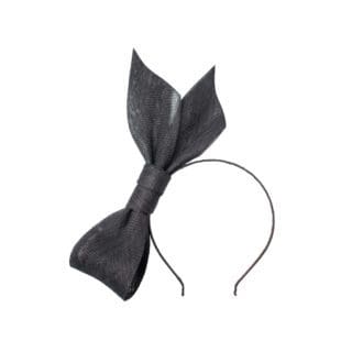 black bow headband on mannequin head on white background