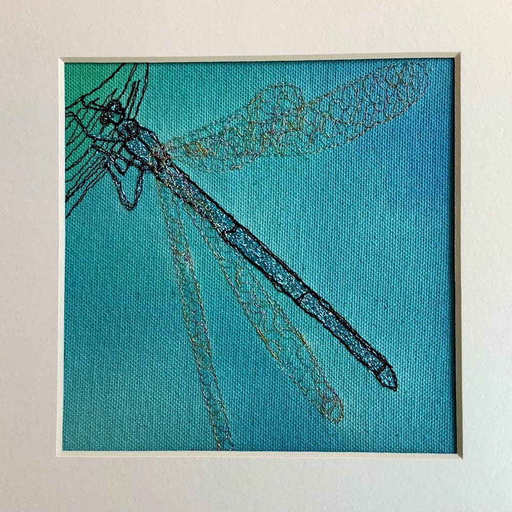 embroidery of a dragonfly on a blue background