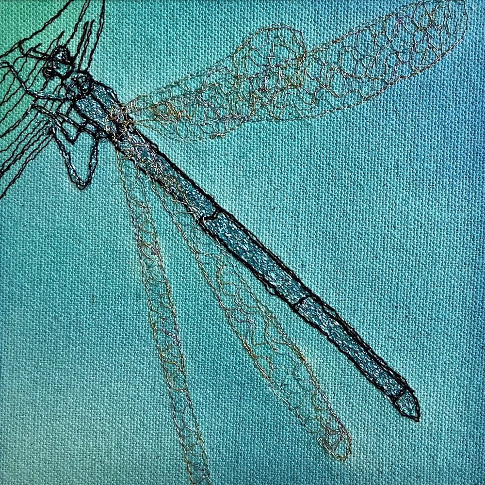 embroidery of a dragonfly on a blue background