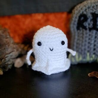 crochet ghost for halloween, a cute white crochet ghost figure with a smiley face and little arms