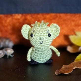 A crochet goblin, he's green with big ears and a cheeky expression.