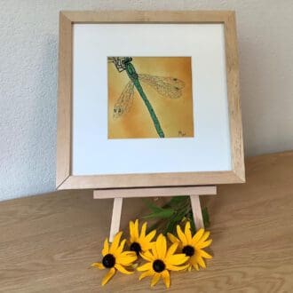 framed embroidery of a green dragonfly on a yellow background