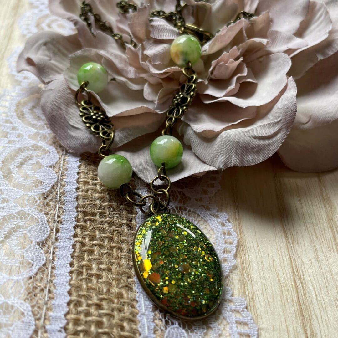 oval resin pendant in sparkly olive green on antique bronze chain with beads 23 inches