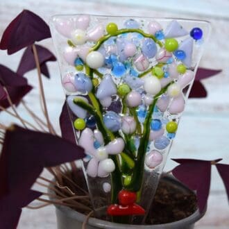 A purple and pink fused glass bunch of flowers plant pot stake