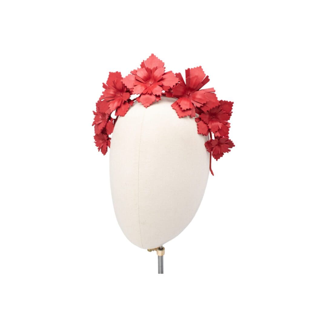 red leather flowers mounted on a headband shown on mannequin head