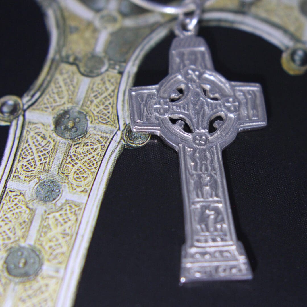 Celtic cross with central cricle and engraved people on the foot of the cross. Sterling silver, available in polished or blackened state.