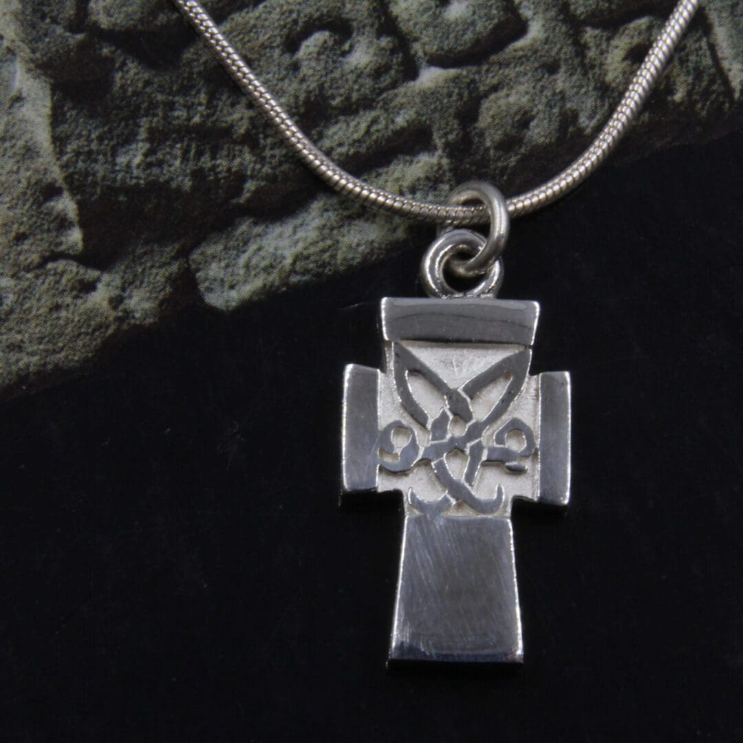 small chunky cross with a Celtic symbole at its center, made in Sterling silver, on a snake chain