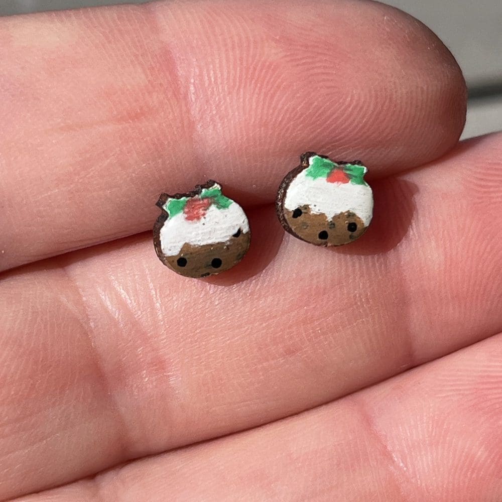 christmas pudding earrings held in a hand