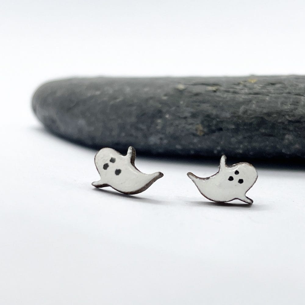 cute wooden ghost earrings on a white background next to a slate stone