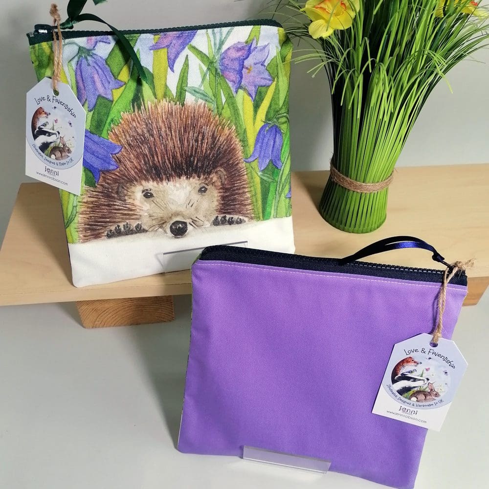 Hedgehog and harebells toiletries bag with light purple back, water resistant lining, chunky zipper fastening and internal pocket. Washbag, cosmetic purse, make-up bag, overnight toiletries bag, pencil case, stationery bag