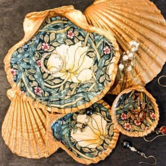 Set of three shells decoupaged with William Morris Pimpernel design, with gold gilded edges and reverse. Shells dishes rest on other gold shells and are draped with jewellery.