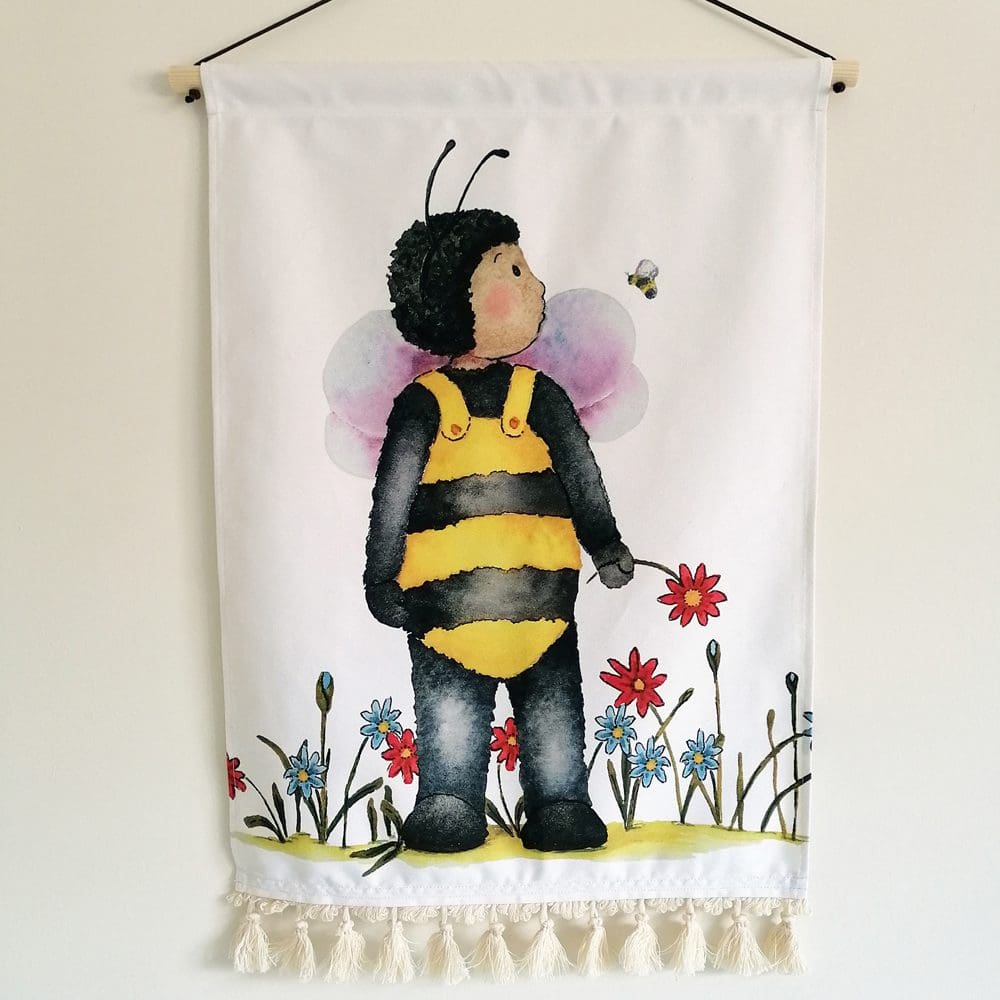 Wall hanging featuring a toddler dressed up as his favourite bumble bee friend. Cotton printed fabric with wooden pole and waxed cotton hanger.