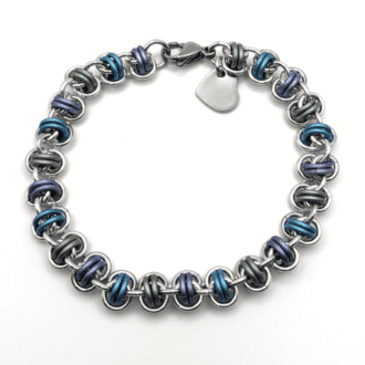 barrel weave chainmaille bracelet made with silver and pastel green, blue and purple rings. with a stainless steel heart charm