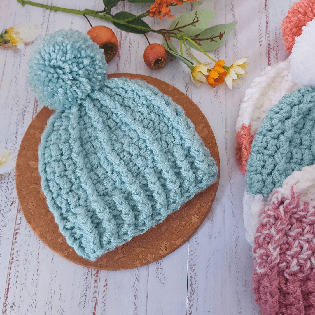 chunky pom pom beanie bobble hats made with 2 strands of acrylic yarn which is soft and cosy. A matching pom pom is made and aatached using a button so they can be detached for washing