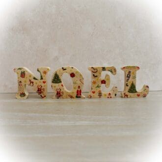 Wooden freestanding letters, spelling NOEL, with a Christmas toy pattern. Christmas decoration.