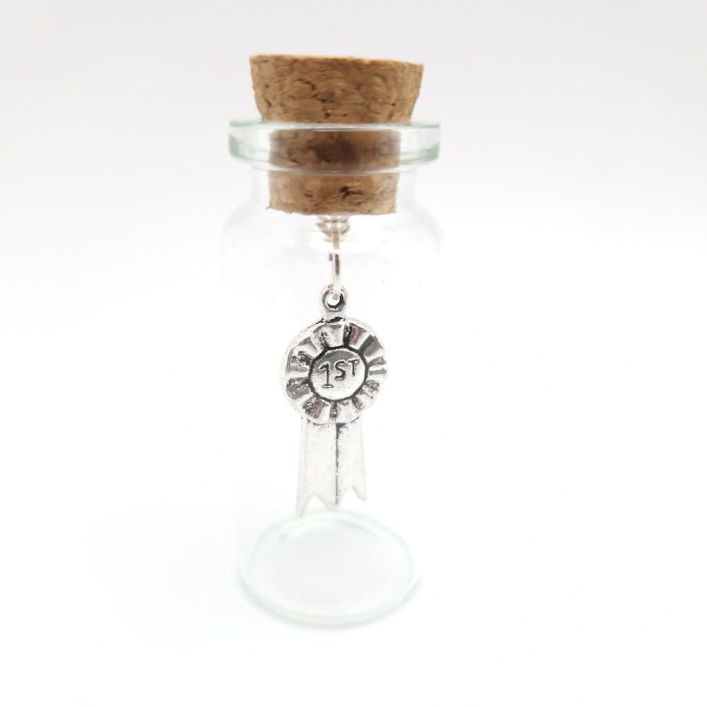 Miniature glass bottle with silver rosette charm inside