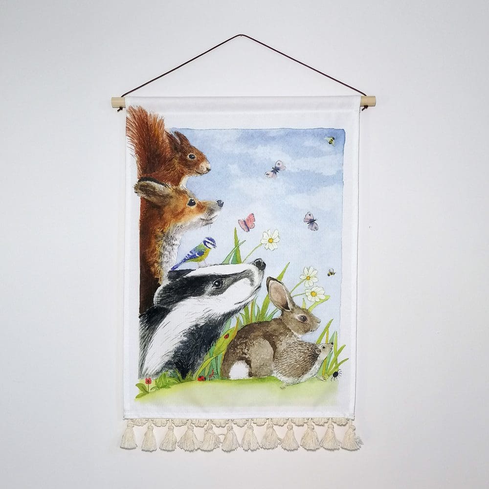 A wall fabric wall hanging featuring a selection of British wildlife including a badger, fox, squirrel, rabbit, hedgehog and an assortment of insects. Printed on heavyweight cotton, the wall hanging has a wooden pole hanger, fine brown waxed cotton chord, and a decorative pale cream cotton tassel border giving a contemporary look to the lovely wall decor.