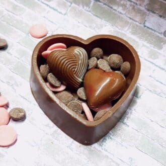 chocolate heart box filled with buttons and two chocolate hearts