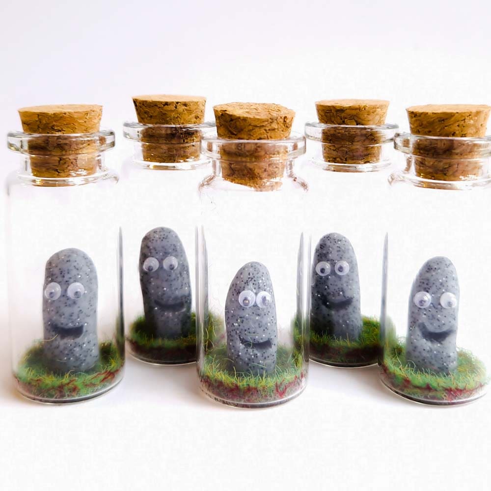 polymer clay rock figures inside miniature glass bottles
