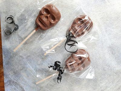 Three chocolate skulls wrapped in cellophane with black ribbon