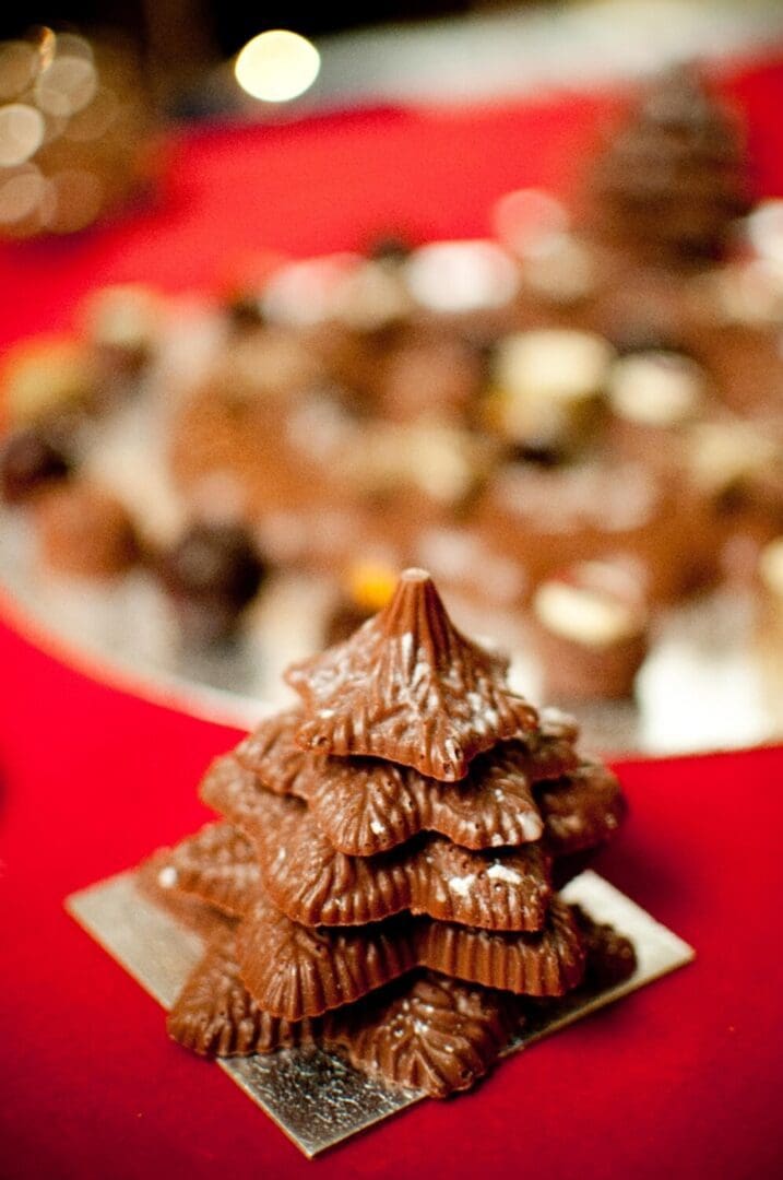 chocolate christmas tree on a red table cloth with chocolates in the background